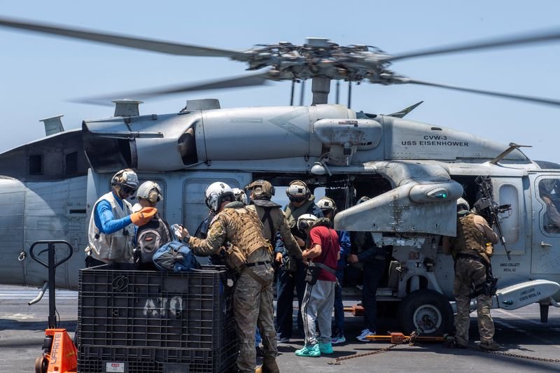 © Reuters. Sailors from the Dwight D. Eisenhower Carrier Strike Group assist distressed mariners rescued from the Liberian-flagged, Greek-owned bulk carrier M/V Tutor that was attacked by Houthis, in the Red Sea, June 15, 2024.  U.S. Naval Forces Central Command/U.S. 5th Fleet/Handout via REUTERS/File Photo