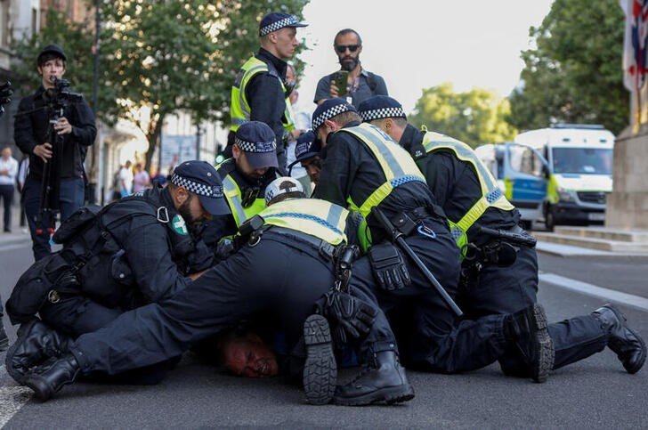 © Reuters. Police officers detain a demonstrator during a protest against illegal immigration outside of Downing Street in London Britain, July 31, 2024. REUTERS/Hollie Adams     